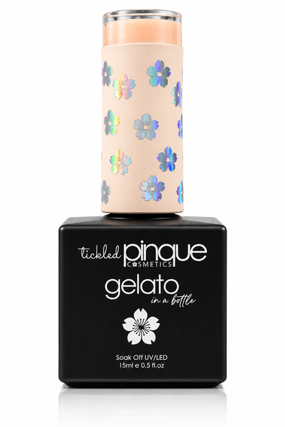 Tickled Pinque Cosmetics Gelato soak off nail polish in a bottle with a black base and a pale peach cap decorated with iridescent blue and purple flowers.