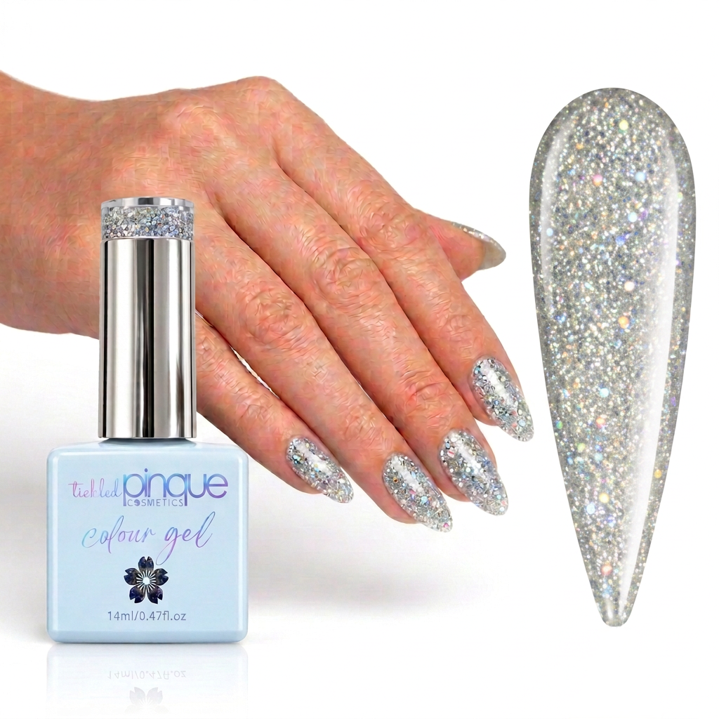 A hand with glittery silver nail polish is shown beside a bottle of Tula Nique Colour Gel and a large nail swatch displaying the sparkling silver finish.
