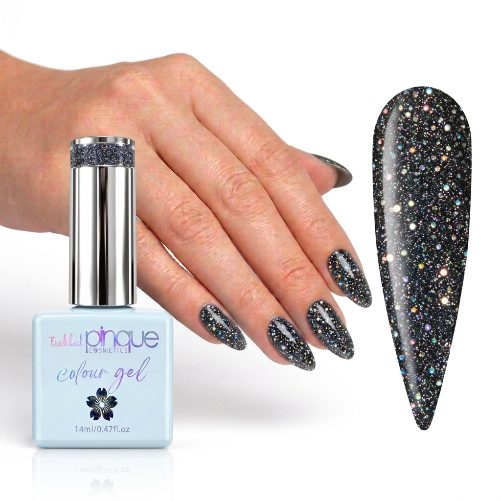 A hand with glittery black gel nail polish is shown beside a bottle of Tattler Cosmetics Colour Gel and a large nail swatch displaying the sparkling finish. The bottle is light blue with a silver cap, and the swatch is black with dense multicolor glitter.